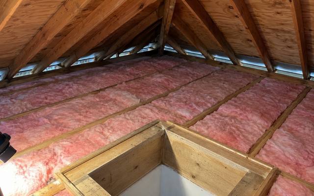 Pink batts covering an attic floor around a framed hatch opening