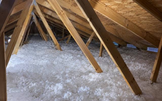 Loose fill blown deep between the braces of an attic truss system, the depth a rebate claim records
